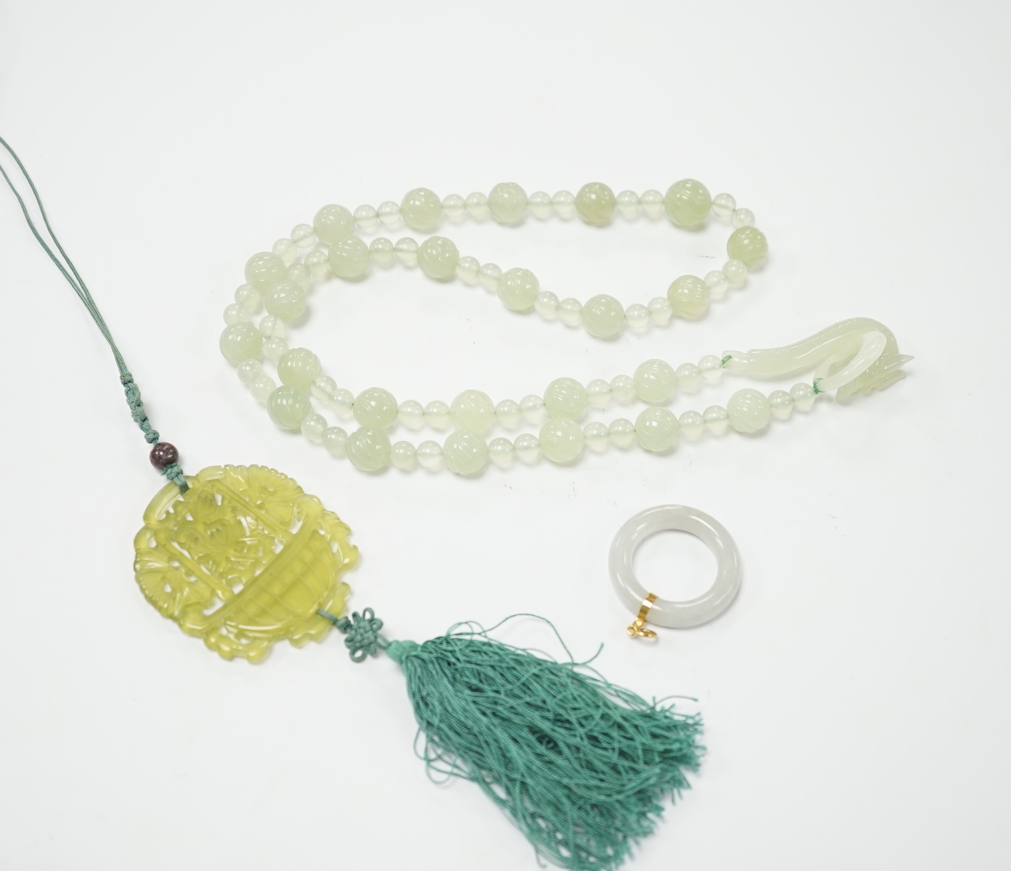A bowenite jade bead necklace with dragon head clasp, circular pendant and carved disc